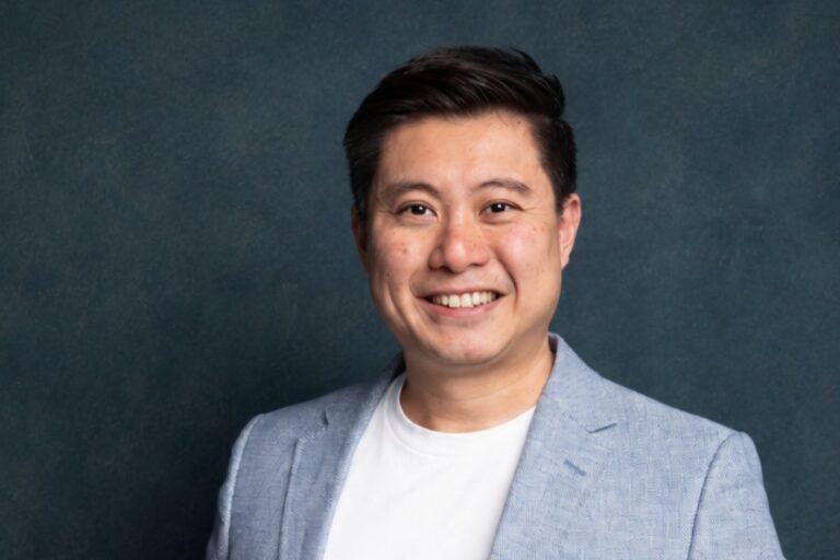 Stephen Soo, business coach for brokers and business owners, smiling in a light blue blazer