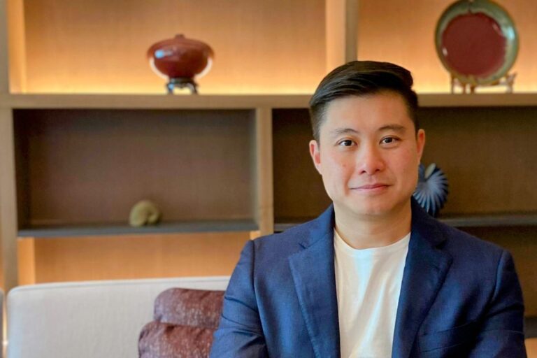 Stephen Soo, business coach for brokers and business owners, seated in a navy blazer